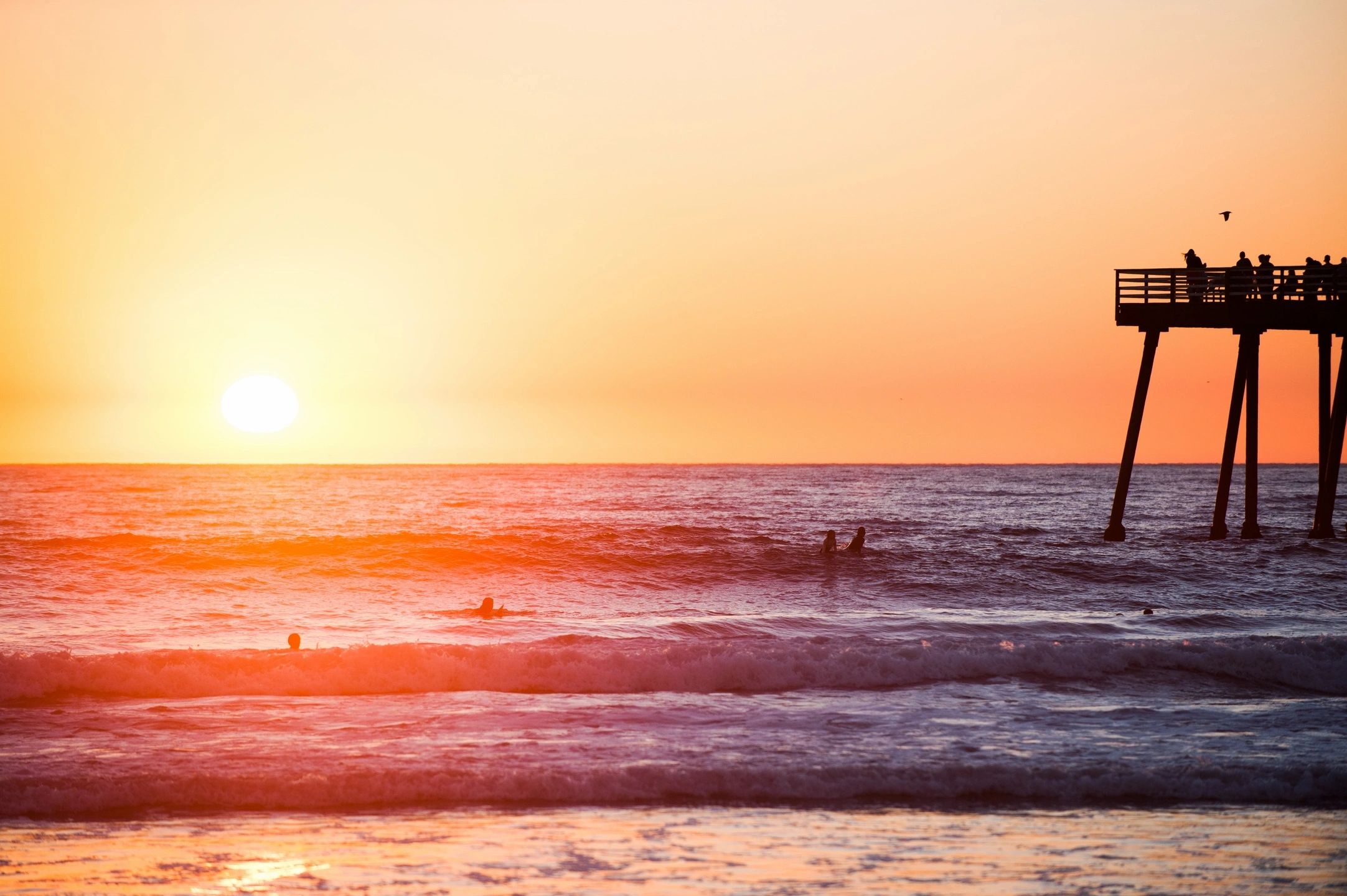 Views of the ocean from shore at sunset.